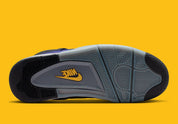 Sneakers Air Jordan 4 Retro en cuir premium, coloris violet et or Lakers, éléments signature Jumpman et amorti Air visible vue de dessous. 