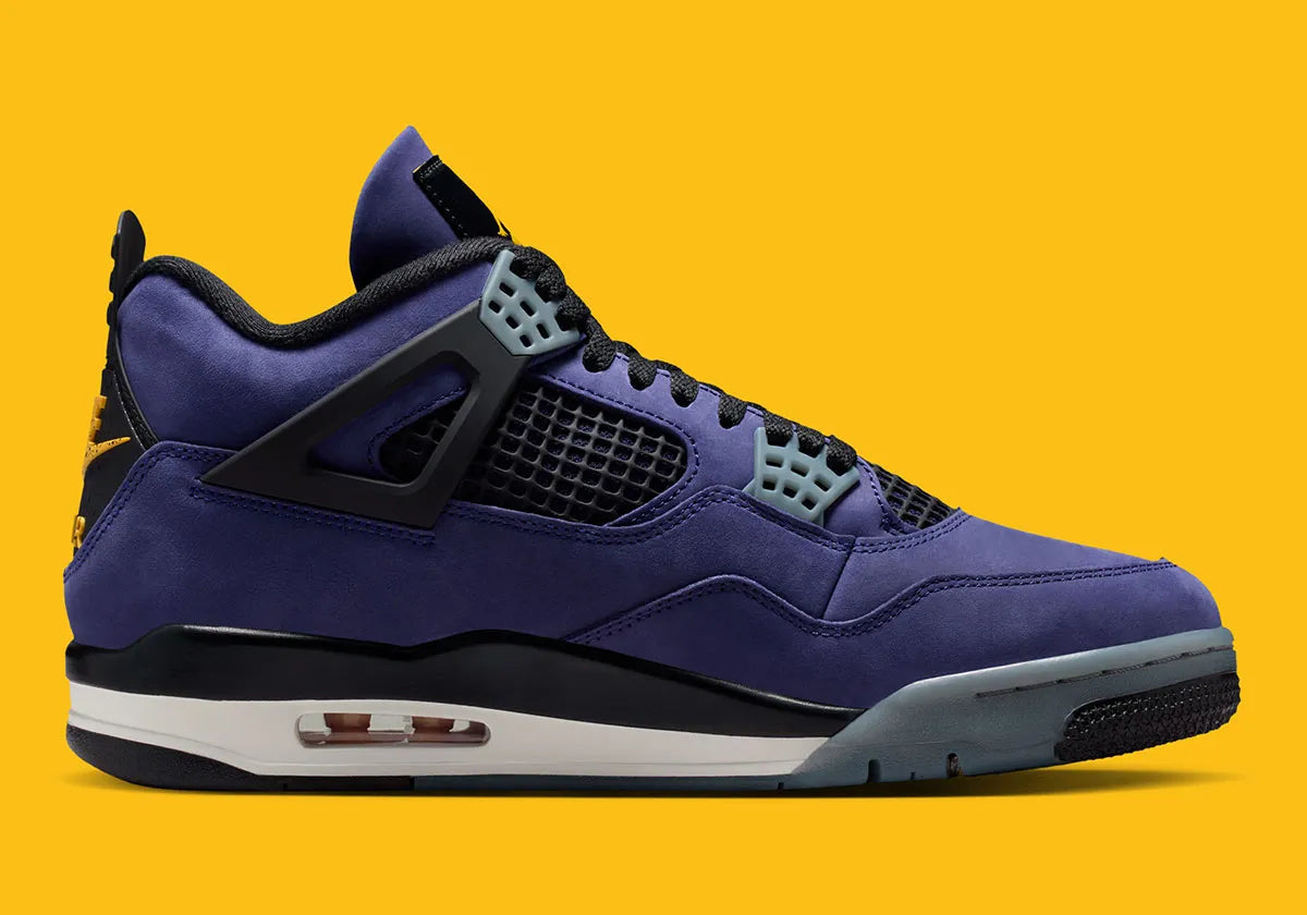 Sneakers Air Jordan 4 Retro en cuir premium, coloris violet et or Lakers, éléments signature Jumpman et amorti Air visible vue de profil intérieur. 