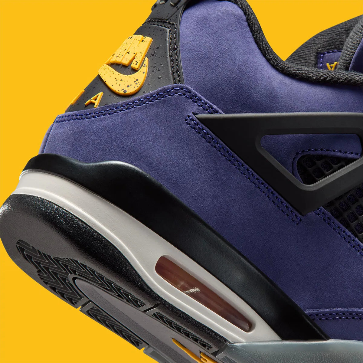 Vue sur les détails arrières de la sneakers Air Jordan 4 Retro en cuir premium, coloris violet et or Lakers, éléments signature Jumpman et amorti Air visible.