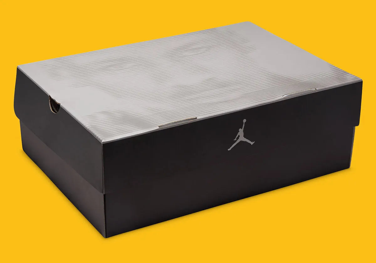 Boite de la sneakers Air Jordan 4 Retro en cuir premium, coloris violet et or Lakers, éléments signature Jumpman et amorti Air visible.