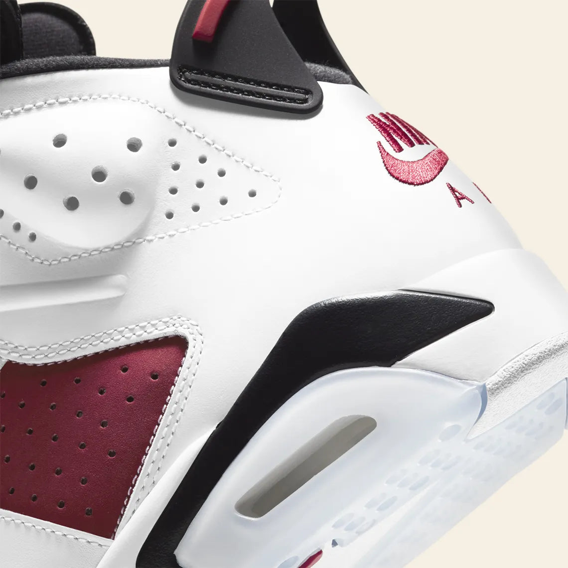 Vue zoomée sur les détails arrières de la Air Jordan 6 Retro Carmine 2021 CT8529-106 en cuir blanc et nubuck rouge Carmine avec détails noirs, Nike Air et semelle translucide.