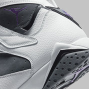 Vue zoomée sur les détails arrières de la Air Jordan 7 Retro Flint CU9307-100 en cuir blanc et suède Flint Grey avec accents Varsity Purple, détails noirs et semelle multicolore.