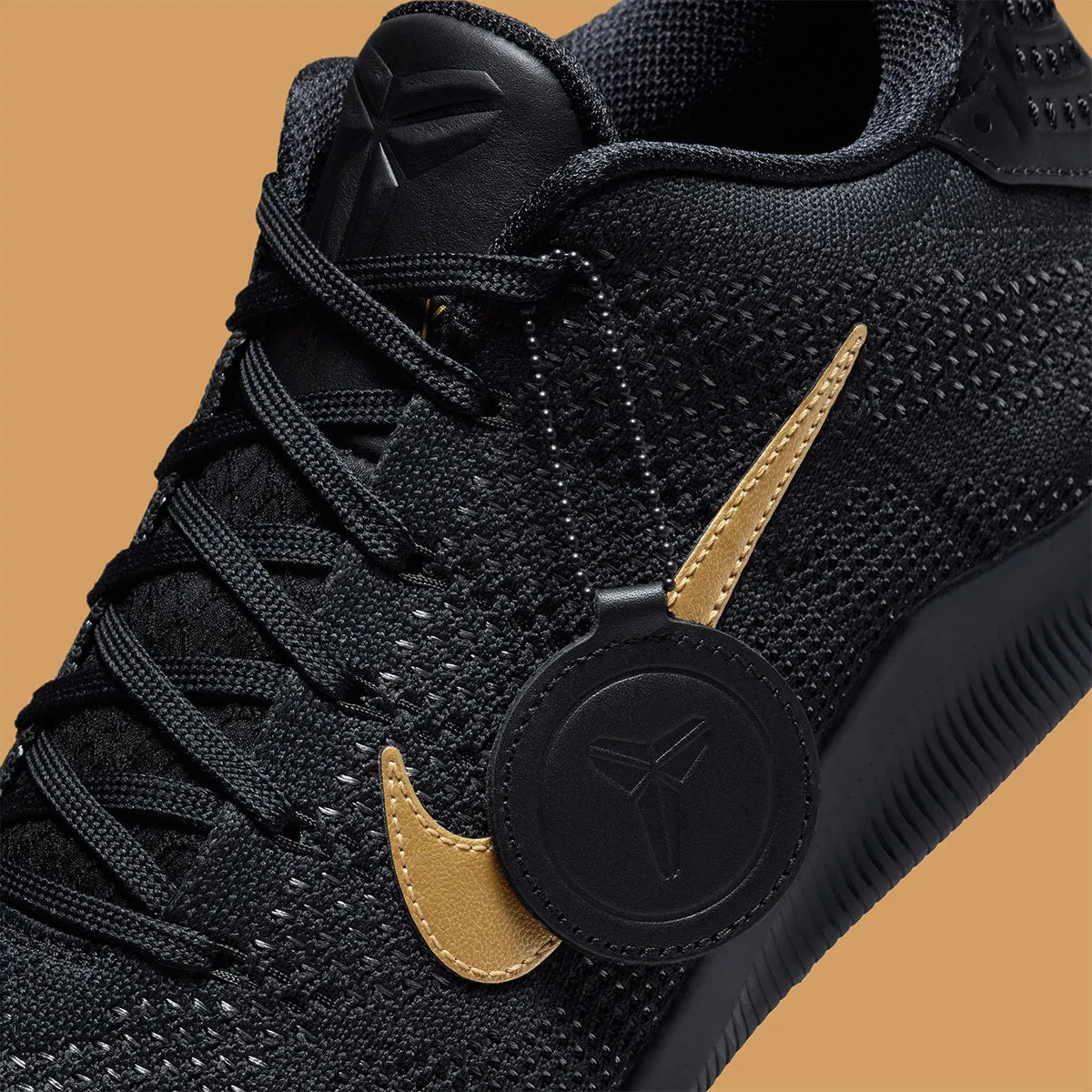 Sneaker Nike Kobe 11 Elite Low Protro noire avec détails dorés en Flyknit et semelle performance React et Air Zoom iconique