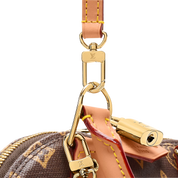 Louis Vuitton Alma Trunk BB, sac en toile Monogram marron avec cuir noir, coins métalliques dorés, cadenas et chaîne amovible.