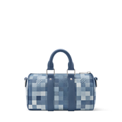Louis Vuitton Keepall Bandoulière 25 Indigo Blue en cuir de veau grainé embossé Monogram bleu indigo avec poignées roulées, bandoulière amovible, fermeture zippée à double curseur et finitions métalliques.