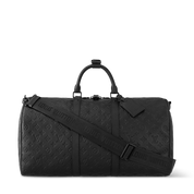 Louis Vuitton Keepall Bandoulière 50 Monogram Shadow Black en cuir de veau Monogram Shadow noir embossé avec poignées roulées, bandoulière amovible, fermeture zippée et finitions métalliques noires.