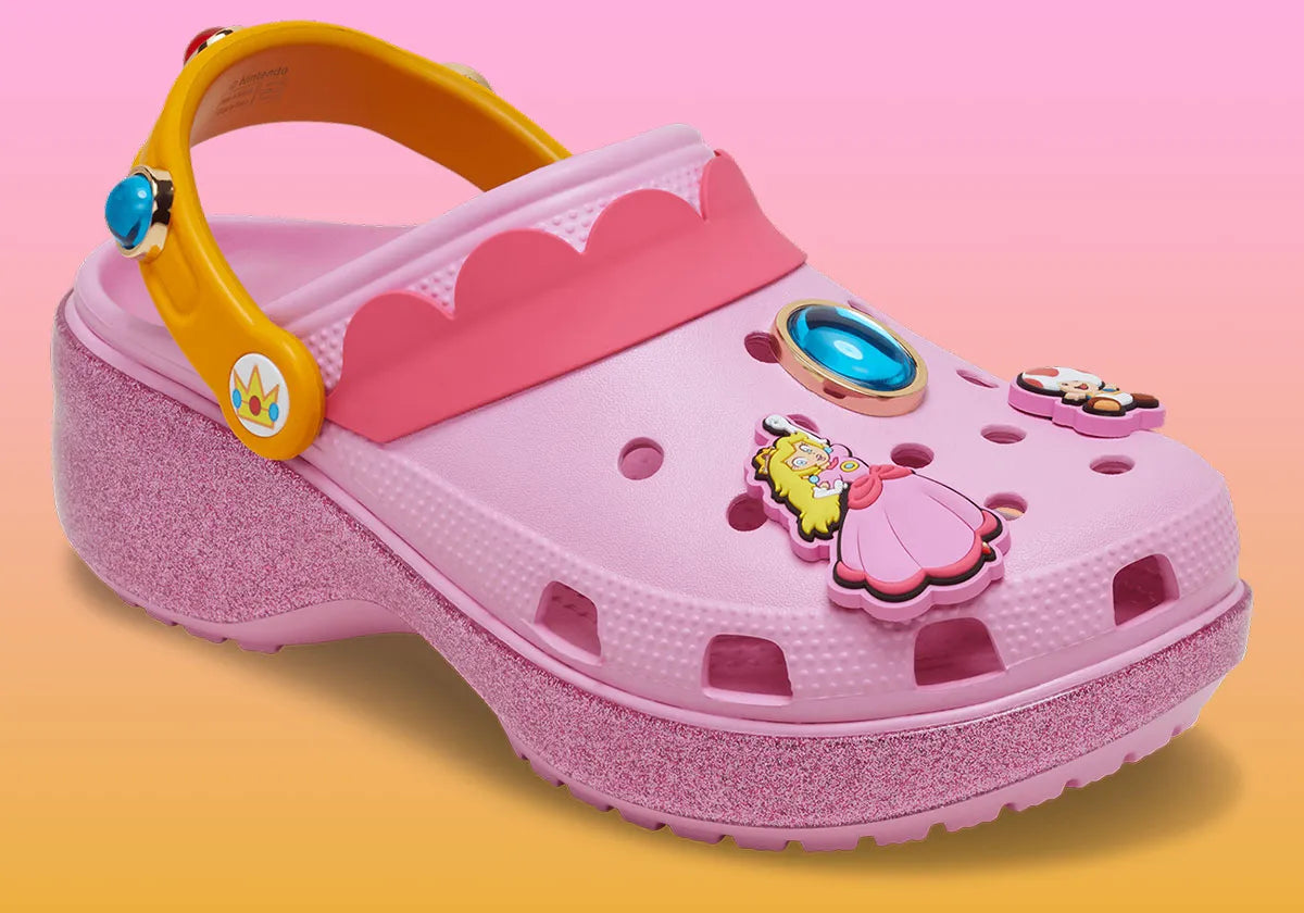 Crocs Classic Platform Clog Super Mario Bros. Princess Peach en résine Croslite™ rose avec semelle plateforme, Jibbitz™ Princess Peach, couronne, étoiles et bride pivotante.