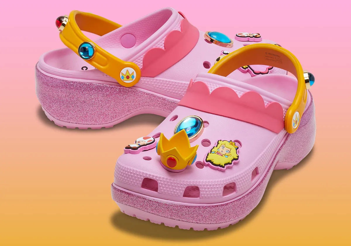 Crocs Classic Platform Clog Super Mario Bros. Princess Peach en résine Croslite™ rose avec semelle plateforme, Jibbitz™ Princess Peach, couronne, étoiles et bride pivotante.
