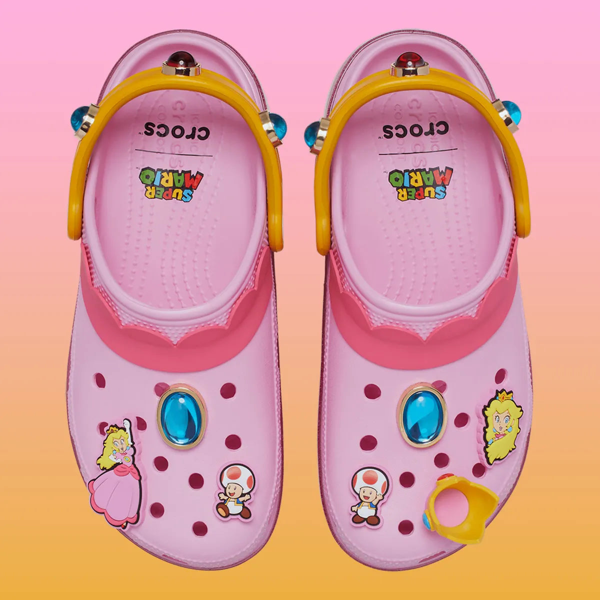 Crocs Classic Platform Clog Super Mario Bros. Princess Peach en résine Croslite™ rose avec semelle plateforme, Jibbitz™ Princess Peach, couronne, étoiles et bride pivotante.
