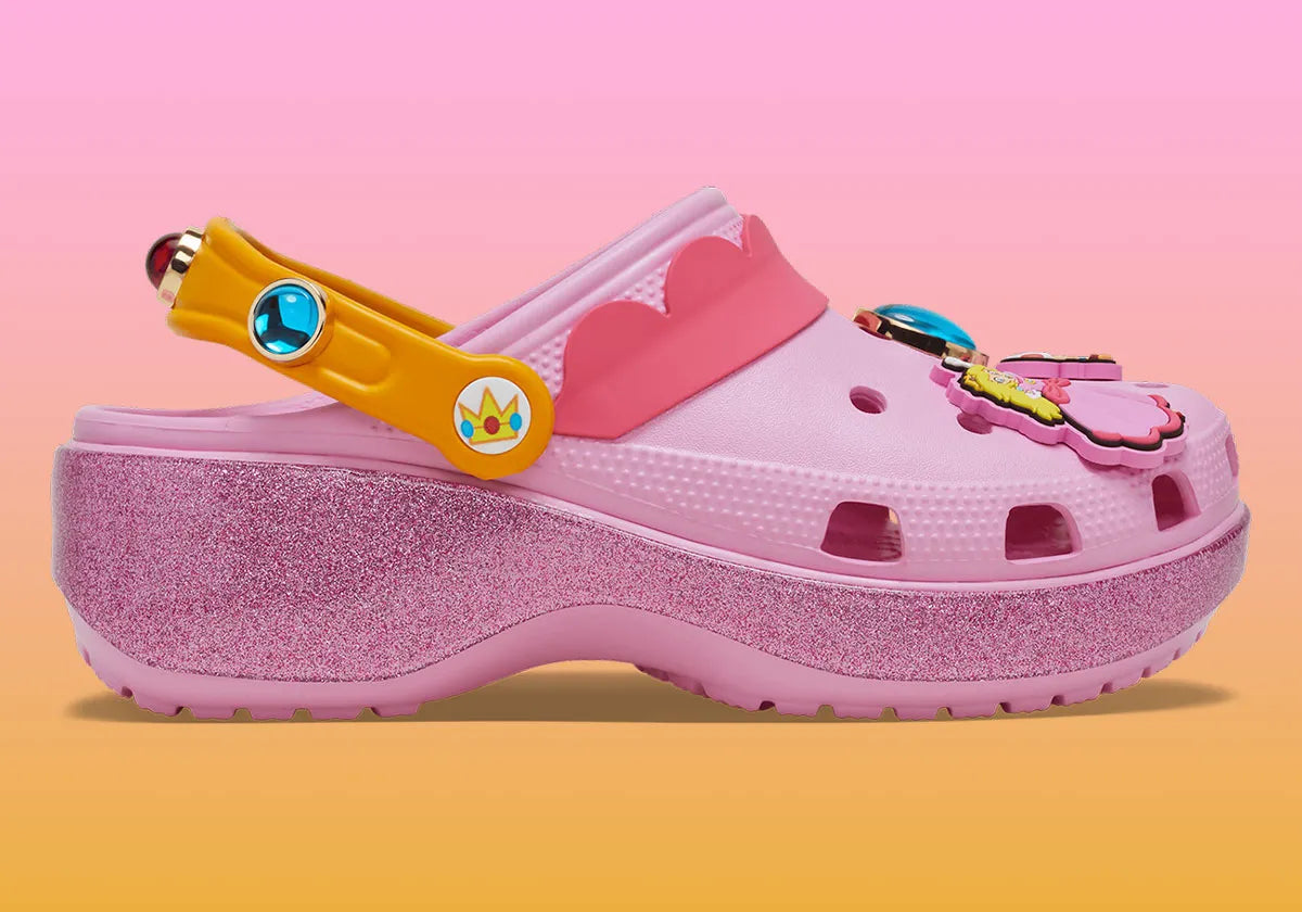 Crocs Classic Platform Clog Super Mario Bros. Princess Peach en résine Croslite™ rose avec semelle plateforme, Jibbitz™ Princess Peach, couronne, étoiles et bride pivotante.