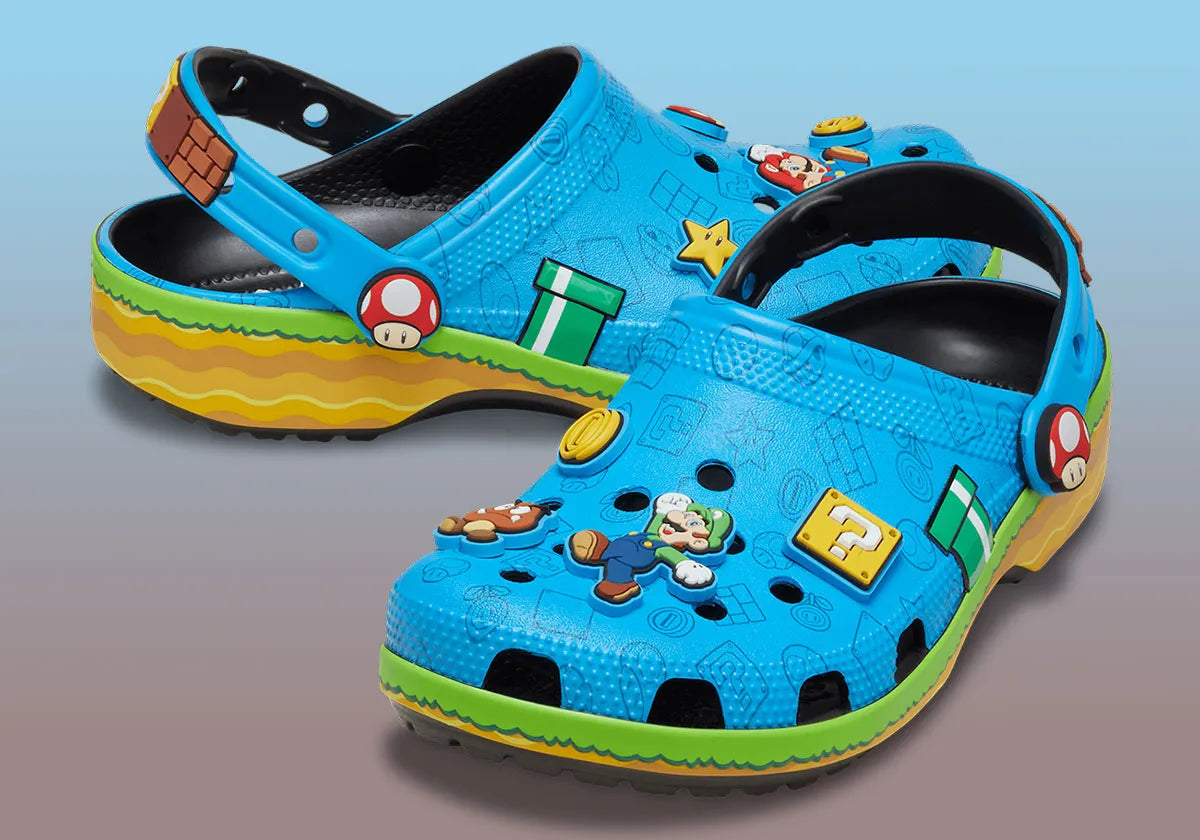 Crocs Classic Clog Super Mario Bros. Super Mario en résine Croslite™ avec Jibbitz™ Mario, Étoile, Super Champignon, blocs « ? », pièces et bride pivotante sur semelle antidérapante.
