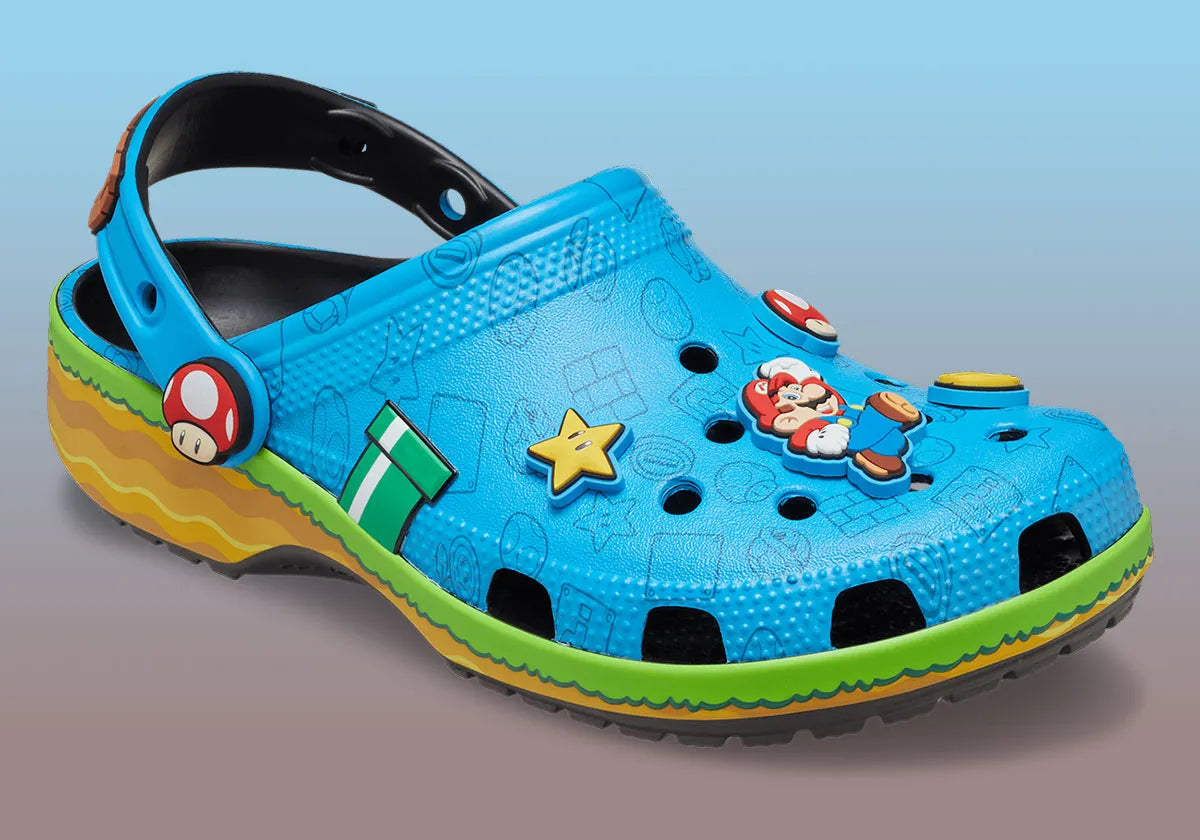 Crocs Classic Clog Super Mario Bros. Super Mario en résine Croslite™ avec Jibbitz™ Mario, Étoile, Super Champignon, blocs « ? », pièces et bride pivotante sur semelle antidérapante.