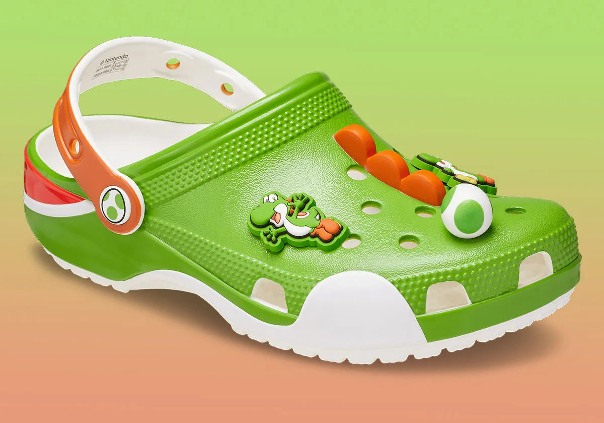 Crocs Classic Clog Super Mario Bros. Yoshi en résine Croslite™ verte avec Jibbitz™ Yoshi, œufs tachetés, fleurs et pièces, bride pivotante et semelle antidérapante.