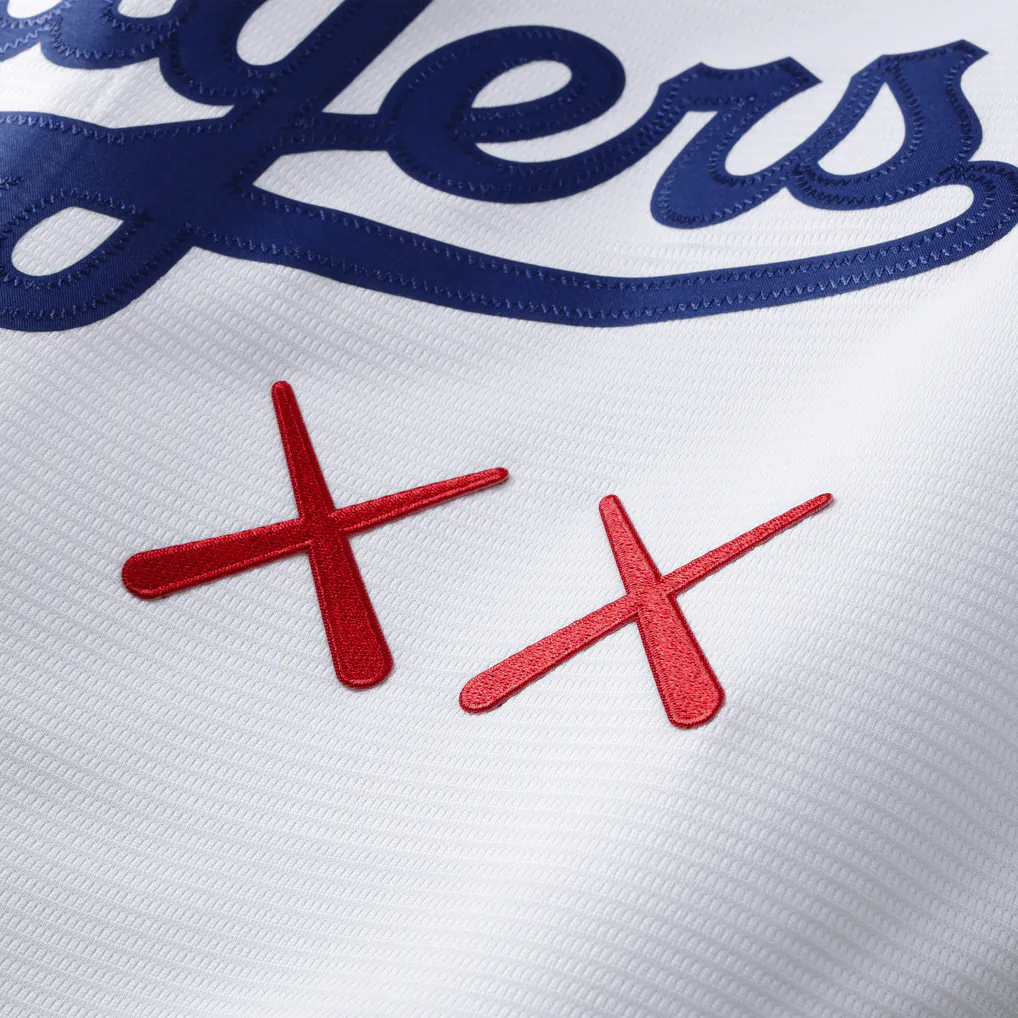 KAWS Nike MLB Stadium Los Angeles Dodgers Jersey White, maillot de baseball blanc avec logo Dodgers bleu, motifs KAWS XX et détails MLB.