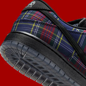 Vue zoomée sur les détails arrières de la Nike SB Dunk Low Nardwuar avec motif tartan multicolore, cuir premium et semelle skate noire.