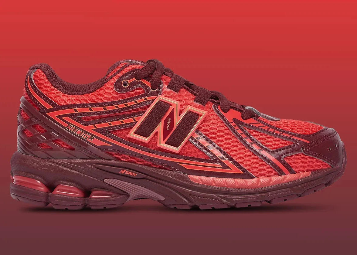 Sneaker New Balance 1906R en mesh gris mercure, cuir synthétique argent, accents rouge crimson, amorti ABZORB et N-ergy, silhouette rétro running premium