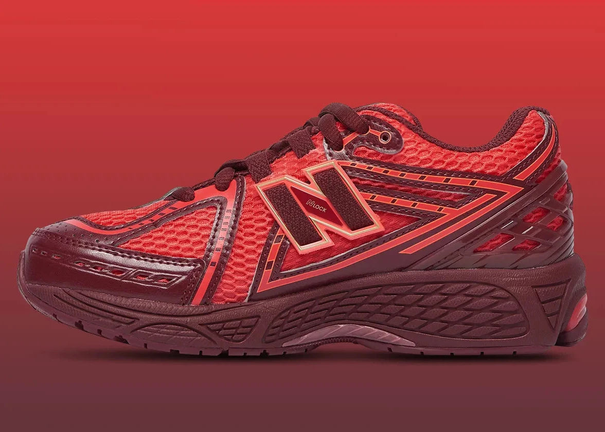 Sneaker New Balance 1906R en mesh gris mercure, cuir synthétique argent, accents rouge crimson, amorti ABZORB et N-ergy, silhouette rétro running premium