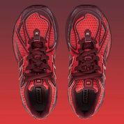 Sneaker New Balance 1906R en mesh gris mercure, cuir synthétique argent, accents rouge crimson, amorti ABZORB et N-ergy, silhouette rétro running premium