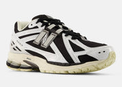 Sneaker New Balance 1906R en mesh blanc, cuir synthétique noir, détails argent métallisé, amorti ABZORB et N-ergy, silhouette rétro running premium
