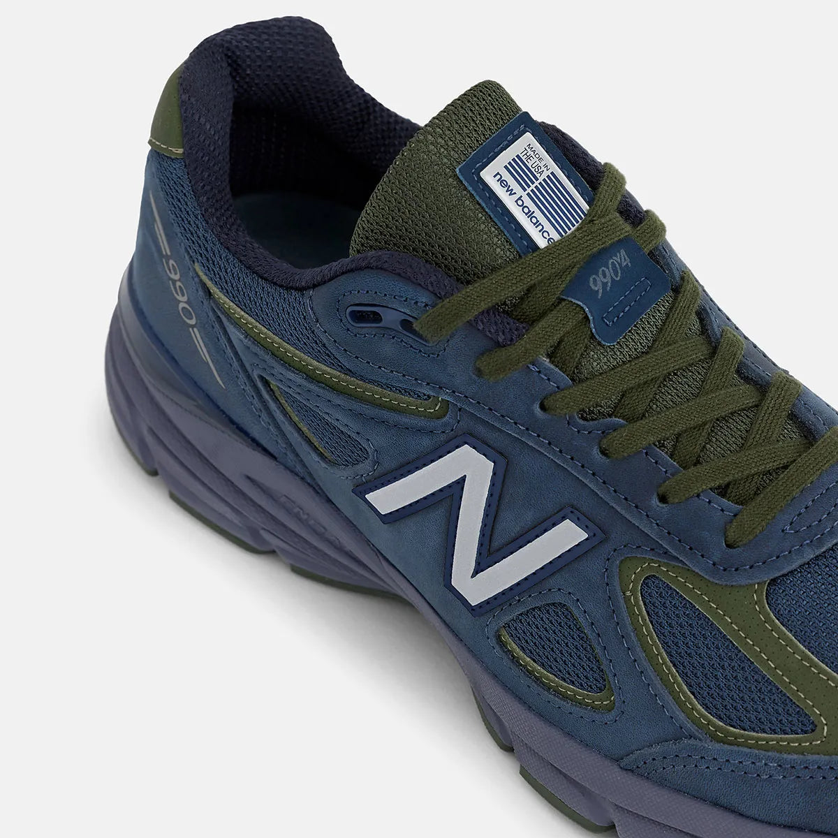 Vue zoomée sur les détails latéraux de la New Balance 990v4 MiUSA Navy Meteorite Kombu U990BG4 en mesh et suède bleu marine, gris Meteorite et vert Kombu avec semelle ENCAP.
