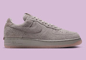 Nike Air Force 1 Low '01 MTA MetroCard en suède gris College Grey avec détails Pink Glaze, hangtag MetroCard et semelle rose translucide.