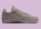 Nike Air Force 1 Low '01 MTA MetroCard en suède gris College Grey avec détails Pink Glaze, hangtag MetroCard et semelle rose translucide.