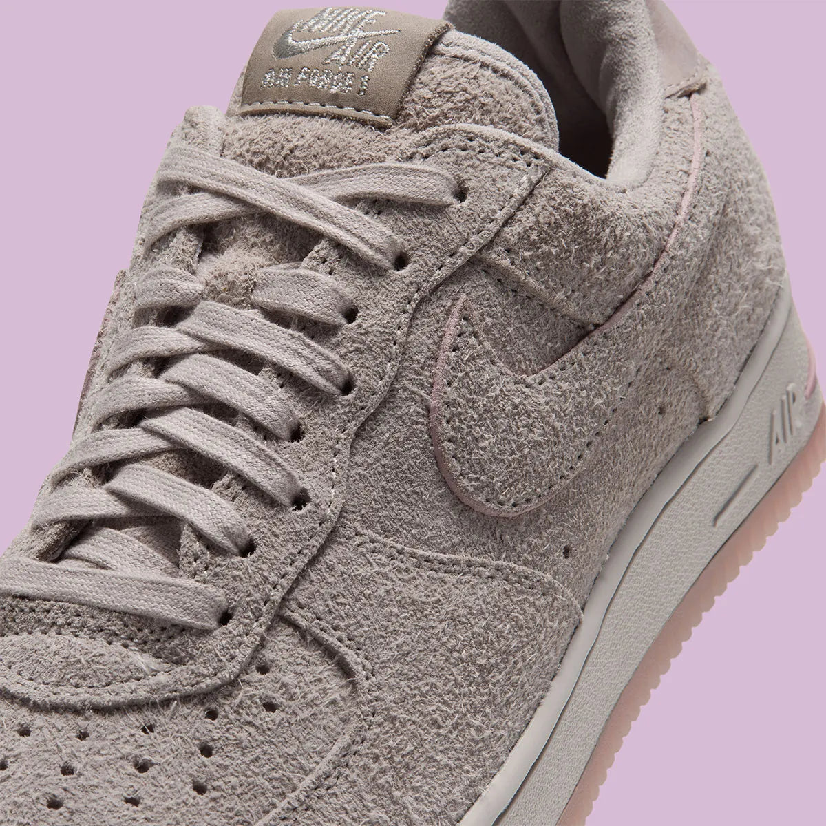 Nike Air Force 1 Low '01 MTA MetroCard en suède gris College Grey avec détails Pink Glaze, hangtag MetroCard et semelle rose translucide.
