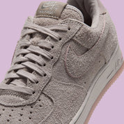 Nike Air Force 1 Low '01 MTA MetroCard en suède gris College Grey avec détails Pink Glaze, hangtag MetroCard et semelle rose translucide.