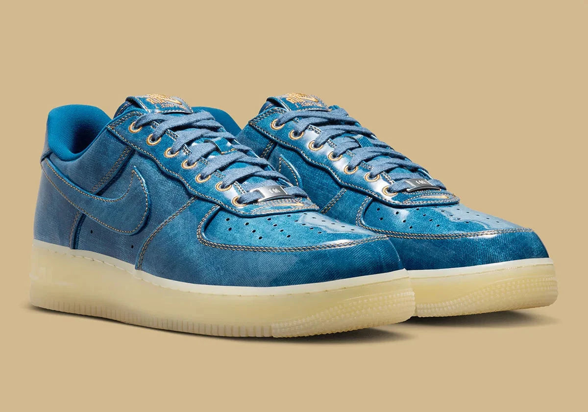 Nike Air Force 1 Low Patent Denim à silhouette basse, avec tige en denim, empiècements vernis contrastés, amorti Nike Air et semelle extérieure en caoutchouc.
