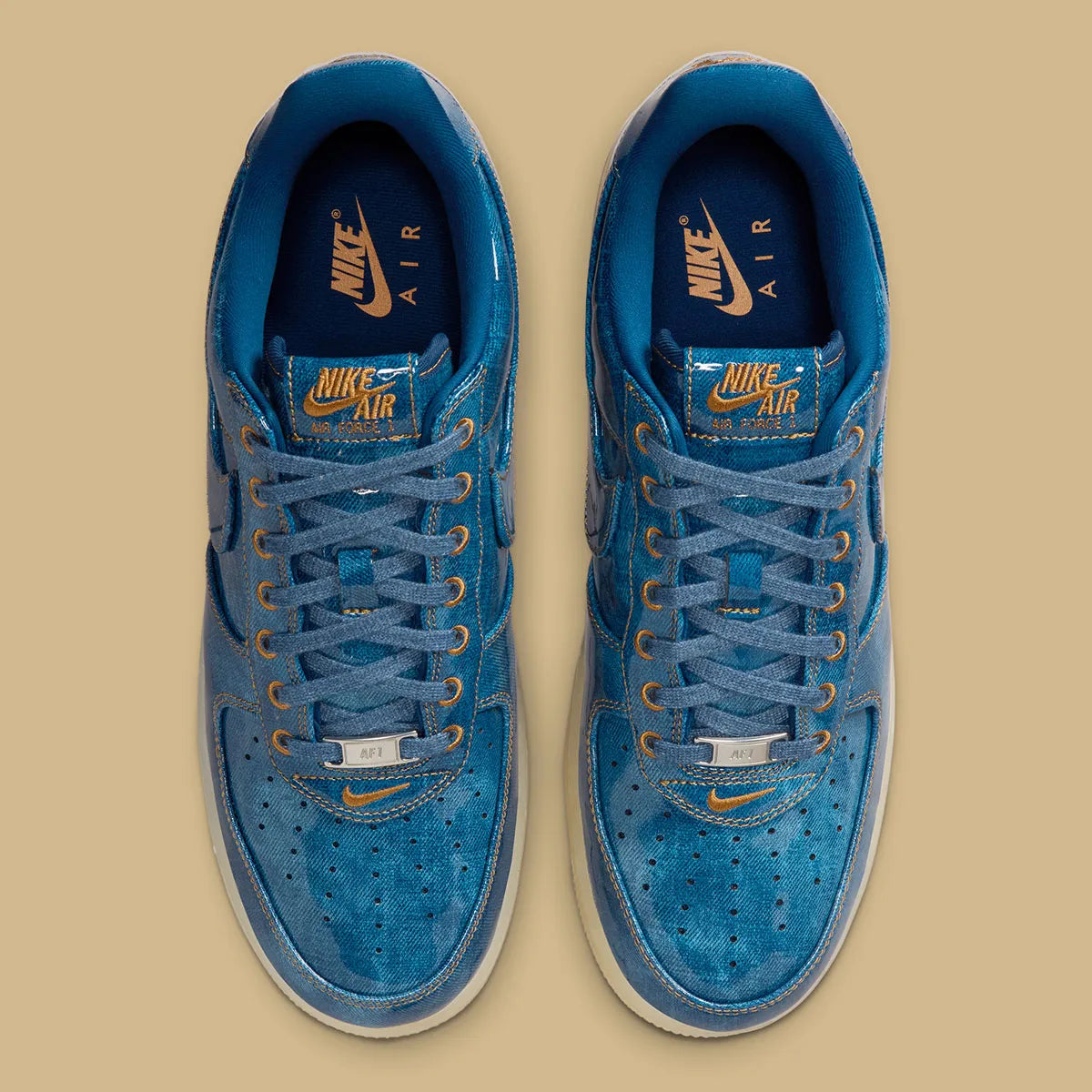 Nike Air Force 1 Low Patent Denim à silhouette basse, avec tige en denim, empiècements vernis contrastés, amorti Nike Air et semelle extérieure en caoutchouc.