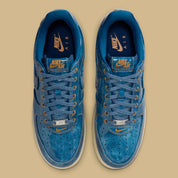 Nike Air Force 1 Low Patent Denim à silhouette basse, avec tige en denim, empiècements vernis contrastés, amorti Nike Air et semelle extérieure en caoutchouc.