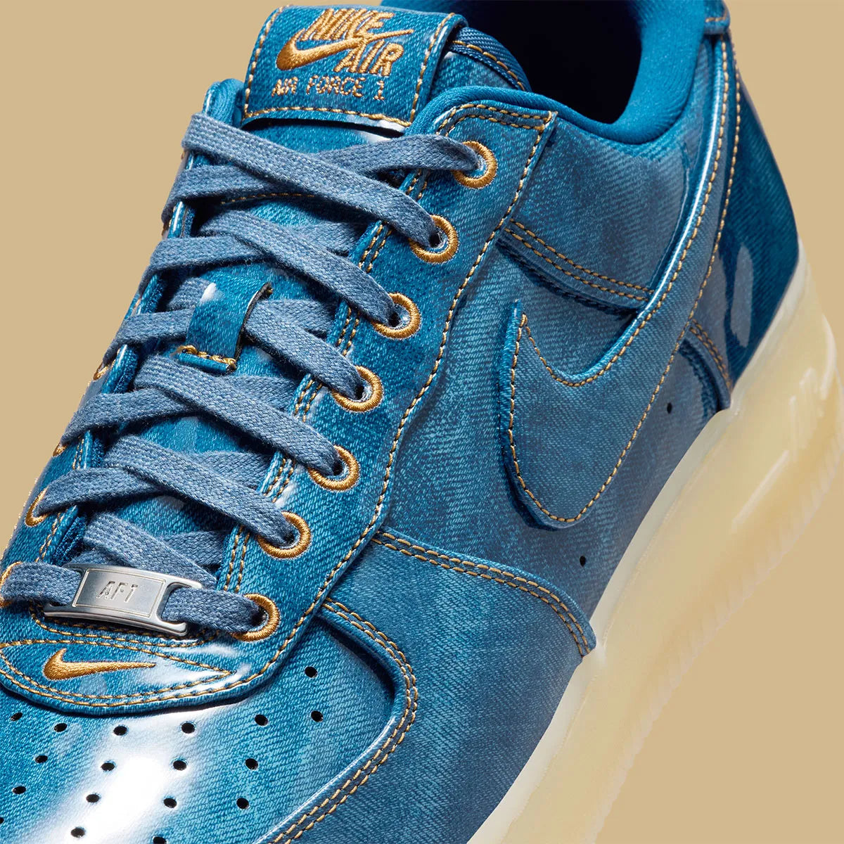 Nike Air Force 1 Low Patent Denim à silhouette basse, avec tige en denim, empiècements vernis contrastés, amorti Nike Air et semelle extérieure en caoutchouc.