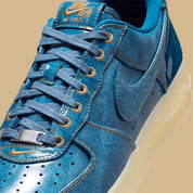 Nike Air Force 1 Low Patent Denim à silhouette basse, avec tige en denim, empiècements vernis contrastés, amorti Nike Air et semelle extérieure en caoutchouc.
