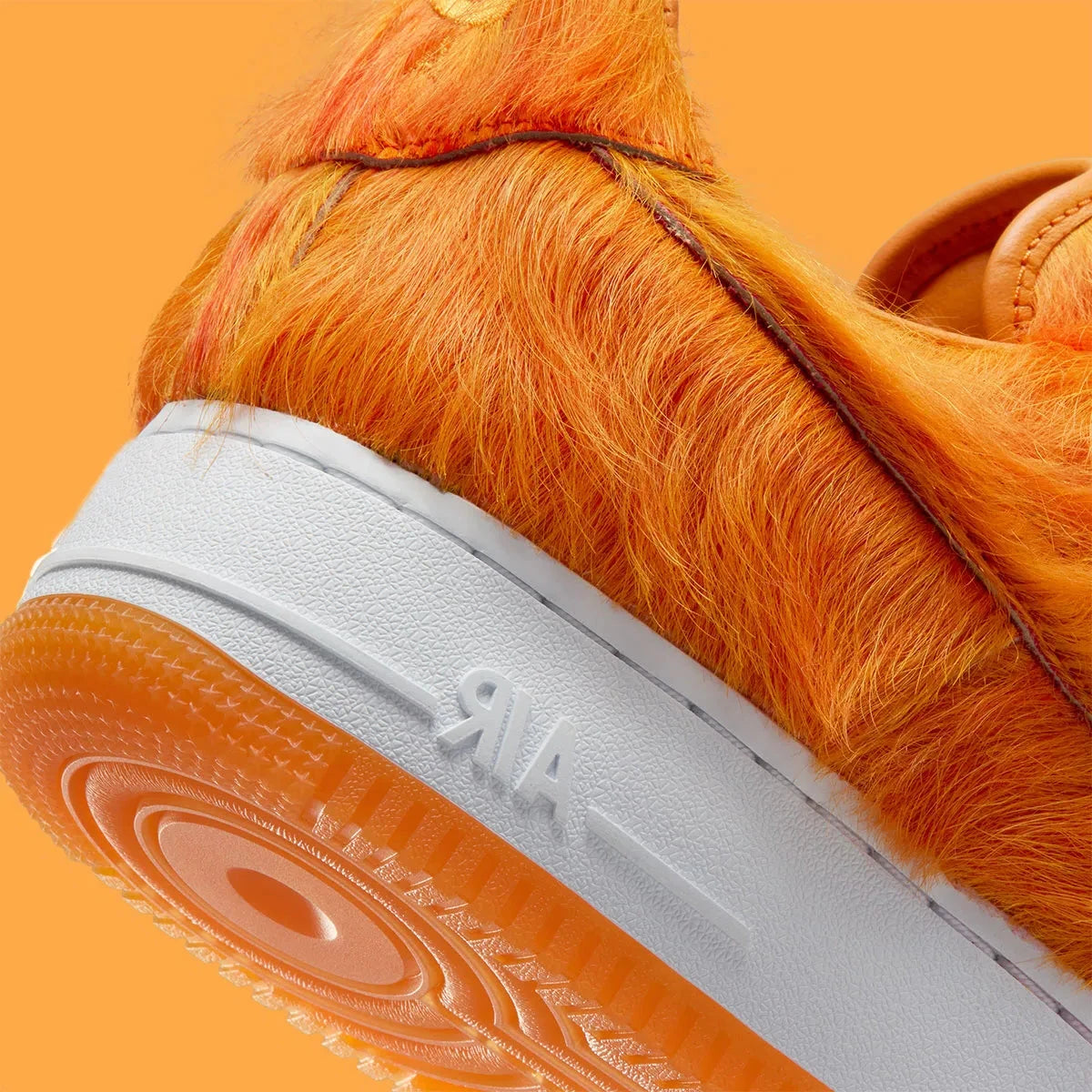 Vue zoomée sur les détails arrières de la Nike Air Force 1 Low Technicolor Tale Orange Pony Hair, sneaker Nike Air Force 1 orange avec empiècements texturés effet pony hair et Swoosh Nike.