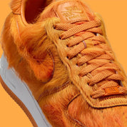 Vue zoomée sur les détails latéraux de la Nike Air Force 1 Low Technicolor Tale Orange Pony Hair, sneaker Nike Air Force 1 orange avec empiècements texturés effet pony hair et Swoosh Nike.