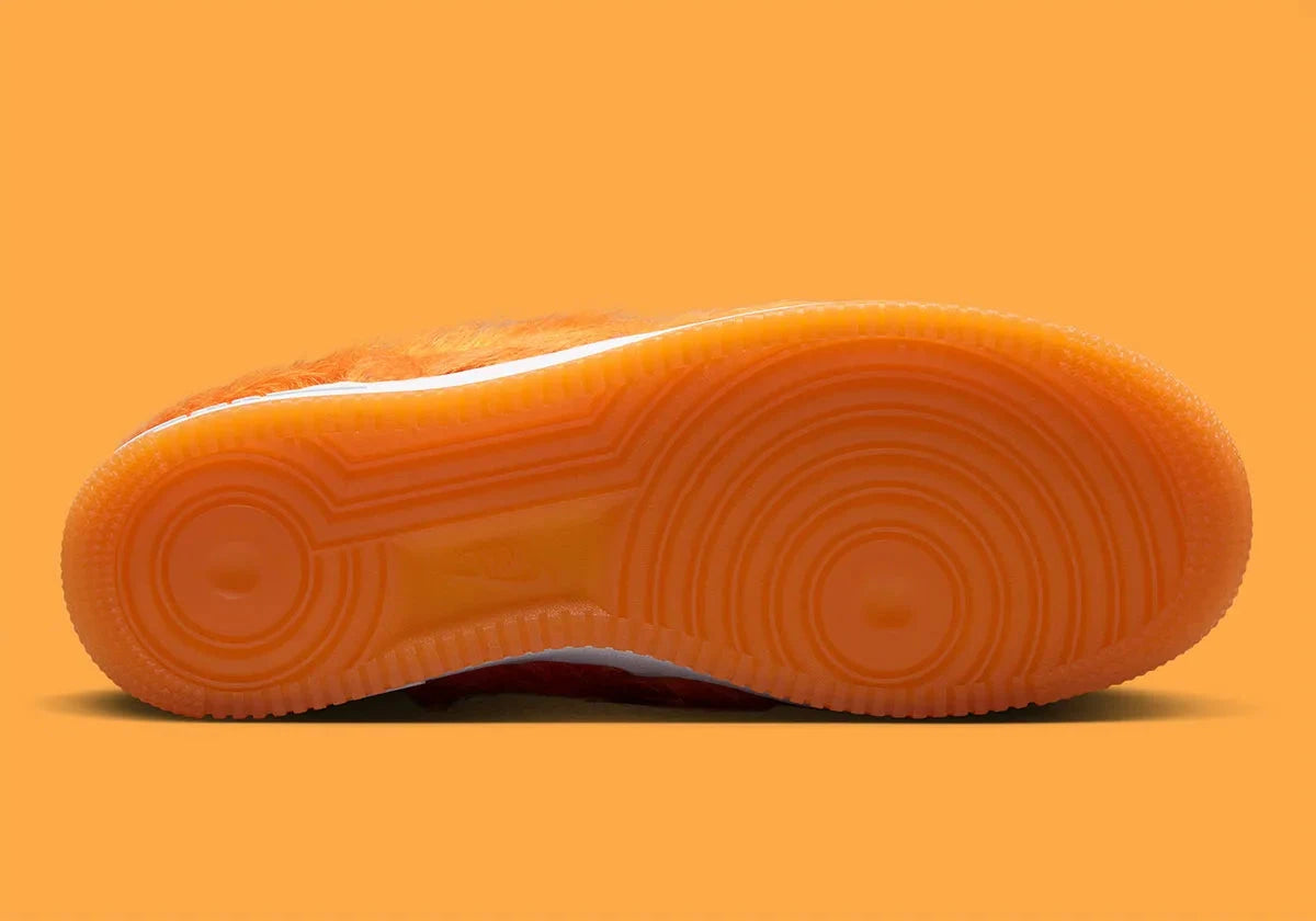 Nike Air Force 1 Low Technicolor Tale Orange Pony Hair, sneaker Nike Air Force 1 orange avec empiècements texturés effet pony hair et Swoosh Nike vue sur la semelle. 