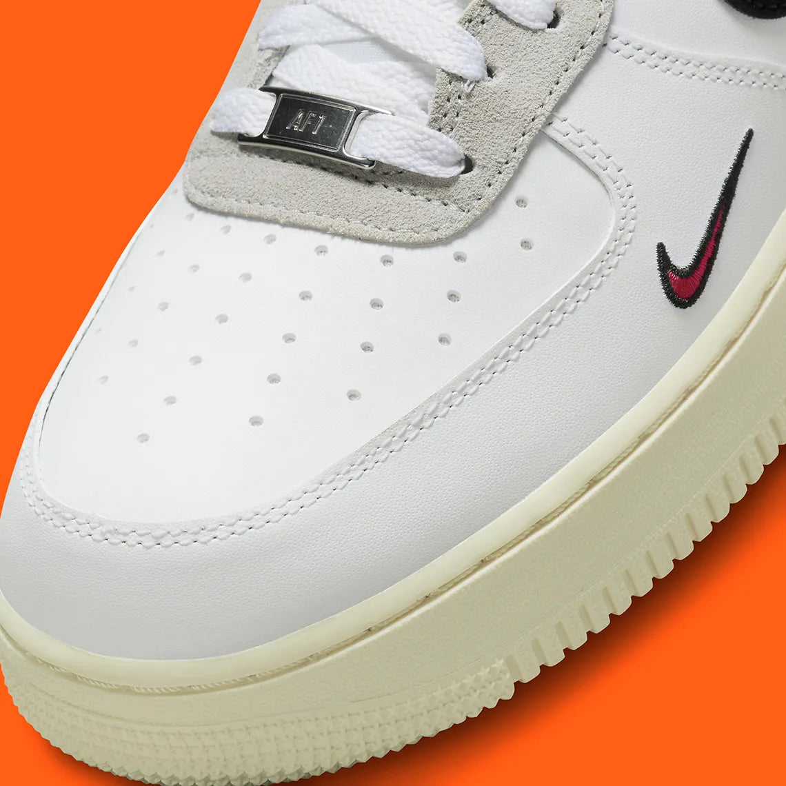 Nike Air Force 1 Low 07 Hoops, sneaker blanche et noire avec détails orange, semelle crème et graphisme basketball au talon vue de profil. 