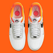 Nike Air Force 1 Low 07 Hoops, sneaker blanche et noire avec détails orange, semelle crème et graphisme basketball au talon vue de profil. 