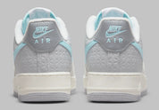 Nike Air Force 1 Low Snowflake DQ0790-001, sneaker Nike Air Force 1 grise en suède avec Swoosh bleu clair et motifs flocons de neige embossés.
