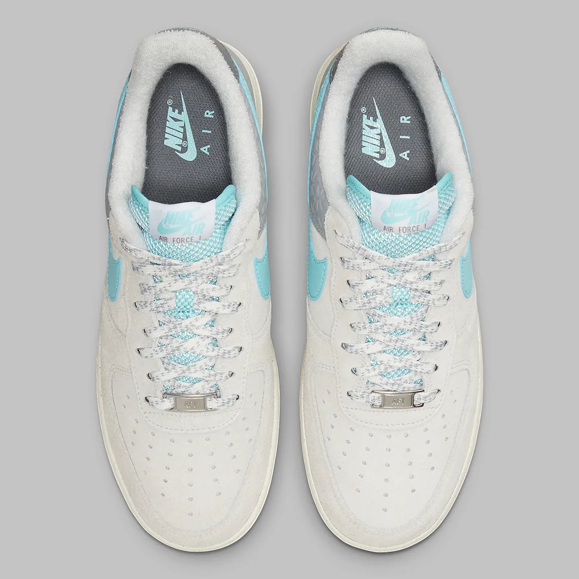 Nike Air Force 1 Low Snowflake DQ0790-001, sneaker Nike Air Force 1 grise en suède avec Swoosh bleu clair et motifs flocons de neige embossés.