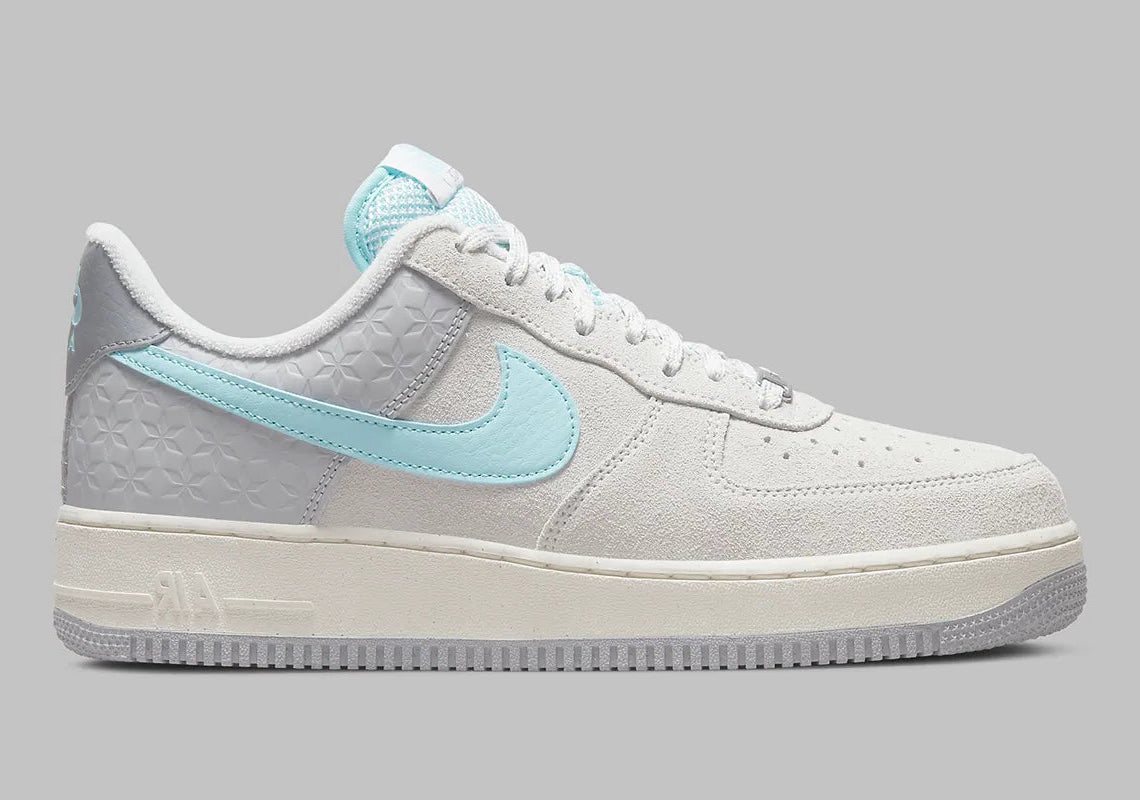 Nike Air Force 1 Low Snowflake DQ0790-001, sneaker Nike Air Force 1 grise en suède avec Swoosh bleu clair et motifs flocons de neige embossés.