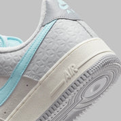 Nike Air Force 1 Low Snowflake DQ0790-001, sneaker Nike Air Force 1 grise en suède avec Swoosh bleu clair et motifs flocons de neige embossés.
