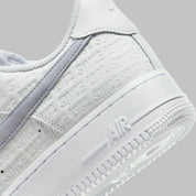 Air Force 1 Low Since 1982, sneaker Nike en cuir Summit White avec Swoosh argenté Metallic Silver et inscriptions Since 1982 en relief vue de profil. 