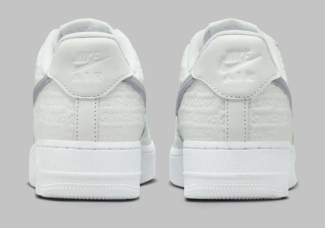 Air Force 1 Low Since 1982, sneaker Nike en cuir Summit White avec Swoosh argenté Metallic Silver et inscriptions Since 1982 en relief vue de profil. 