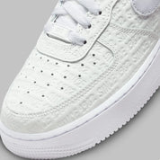 Air Force 1 Low Since 1982, sneaker Nike en cuir Summit White avec Swoosh argenté Metallic Silver et inscriptions Since 1982 en relief vue de profil. 