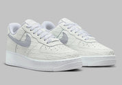 Air Force 1 Low Since 1982, sneaker Nike en cuir Summit White avec Swoosh argenté Metallic Silver et inscriptions Since 1982 en relief vue de profil. 
