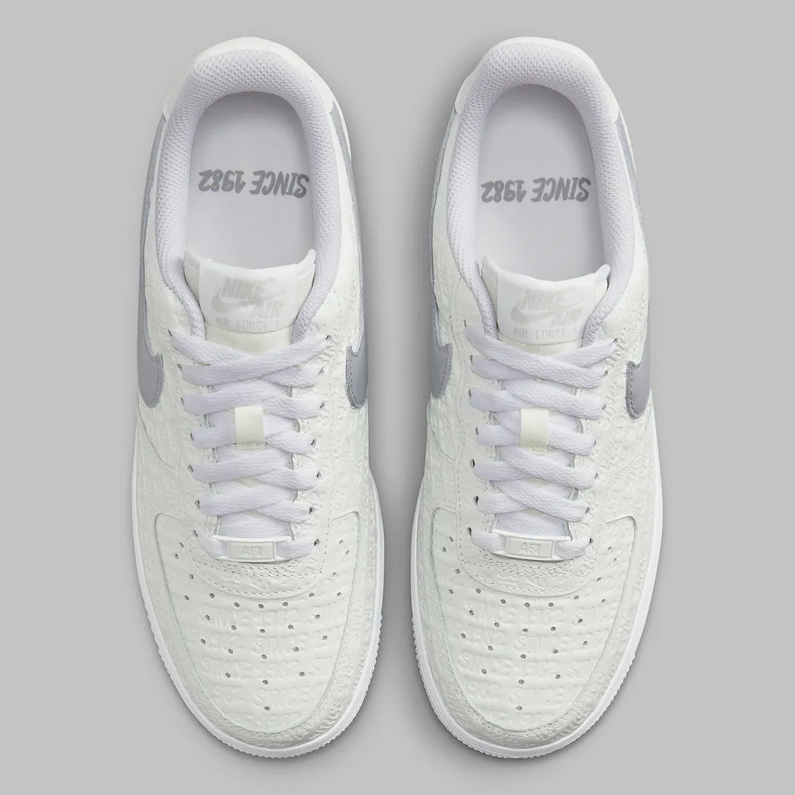 Air Force 1 Low Since 1982, sneaker Nike en cuir Summit White avec Swoosh argenté Metallic Silver et inscriptions Since 1982 en relief vue de profil. 