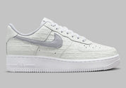 Air Force 1 Low Since 1982, sneaker Nike en cuir Summit White avec Swoosh argenté Metallic Silver et inscriptions Since 1982 en relief vue de profil. 