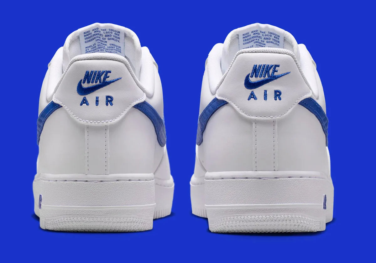 Nike Air Force 1 Low '07 blanche et Game Royal, avec tige en cuir, Swoosh effet fibre de carbone, amorti Nike Air et semelle en caoutchouc.