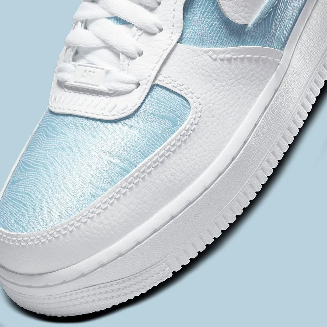 Air Force 1 LXX Glacier Blue, sneaker Nike bleu glacier et blanche avec panneaux en cuir et textile et Swoosh déconstruit.